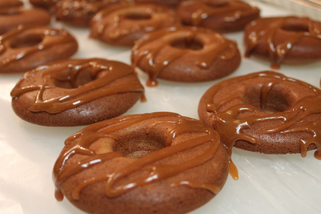 Rows of golden doughnuts drizzled with gooey and sweet homemade caramel sauce.