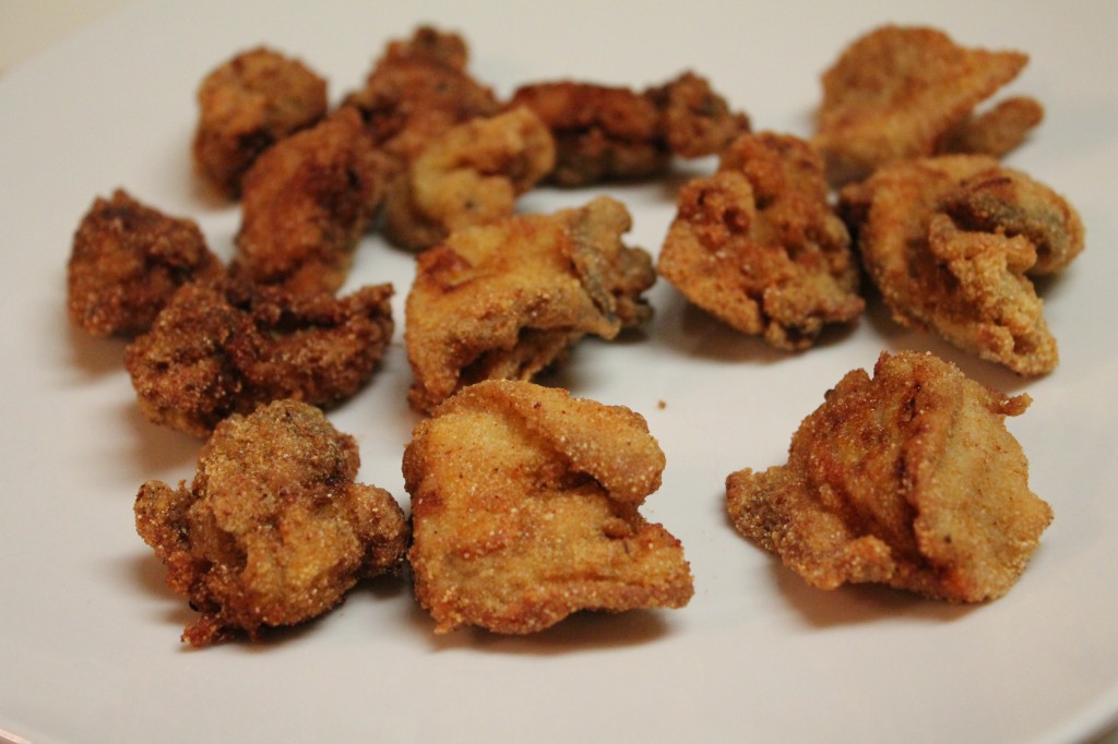 Golden fried oysters served on a white plate. This recipe is fool-proof and has minimal ingredients.