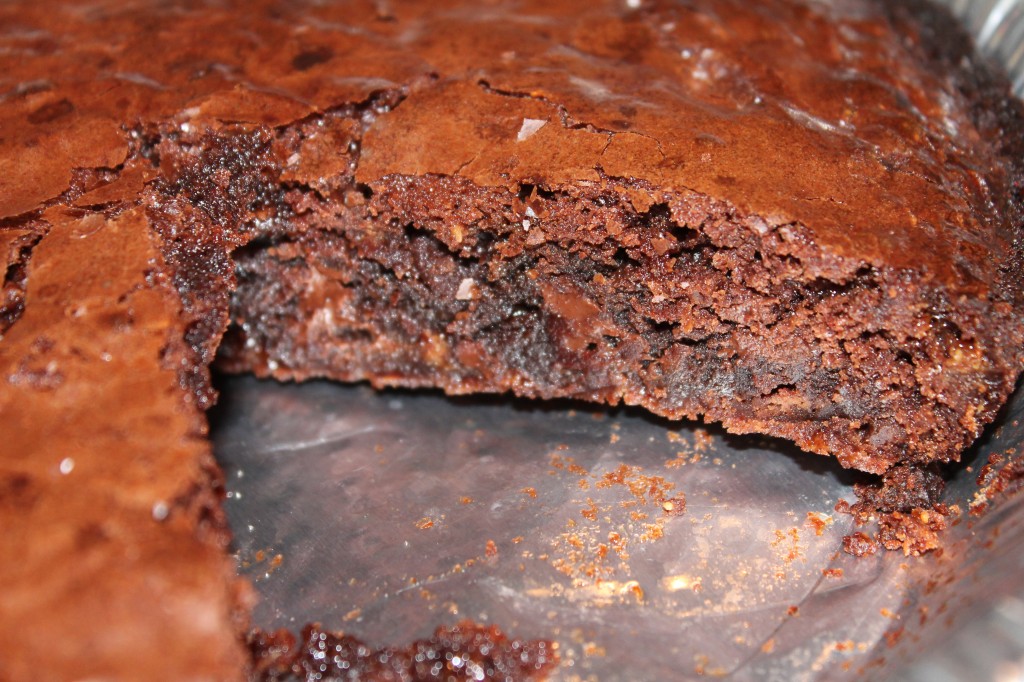 A pan of Chocolate and Toffee Chip Brownies. One slice is removed. 