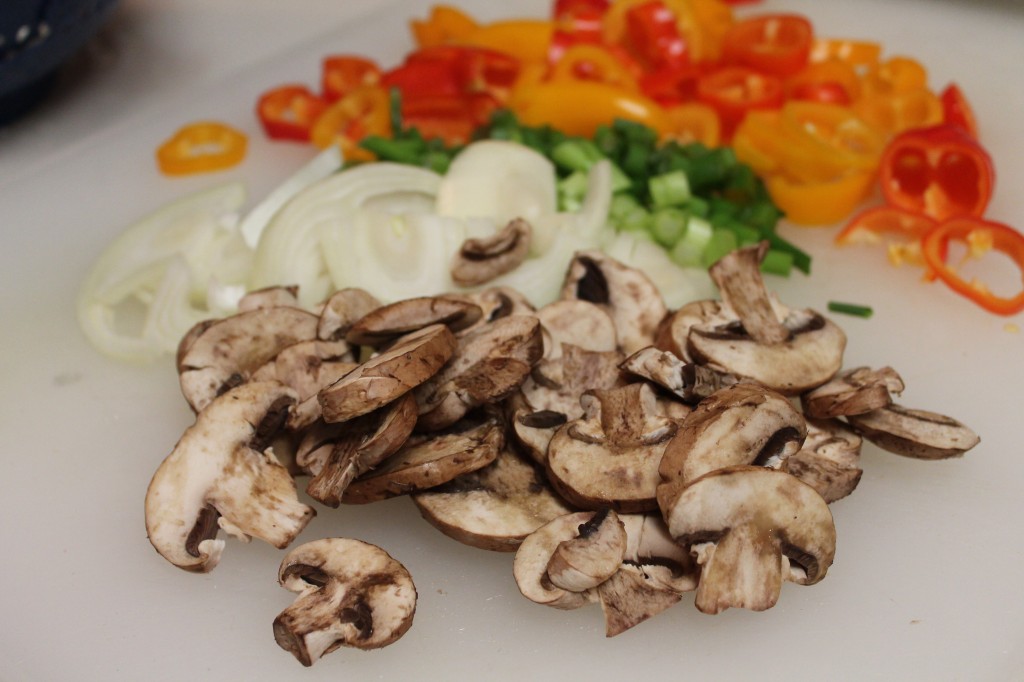 A variety of chopped fresh vegetables on a cutting board. These veggies pack a tasty punch so no salt is needed for these smothered pork chops!