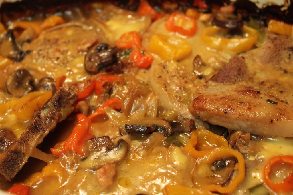 Smothered pork chops topped with peppers, onions and mushrooms in a creamy sauce.