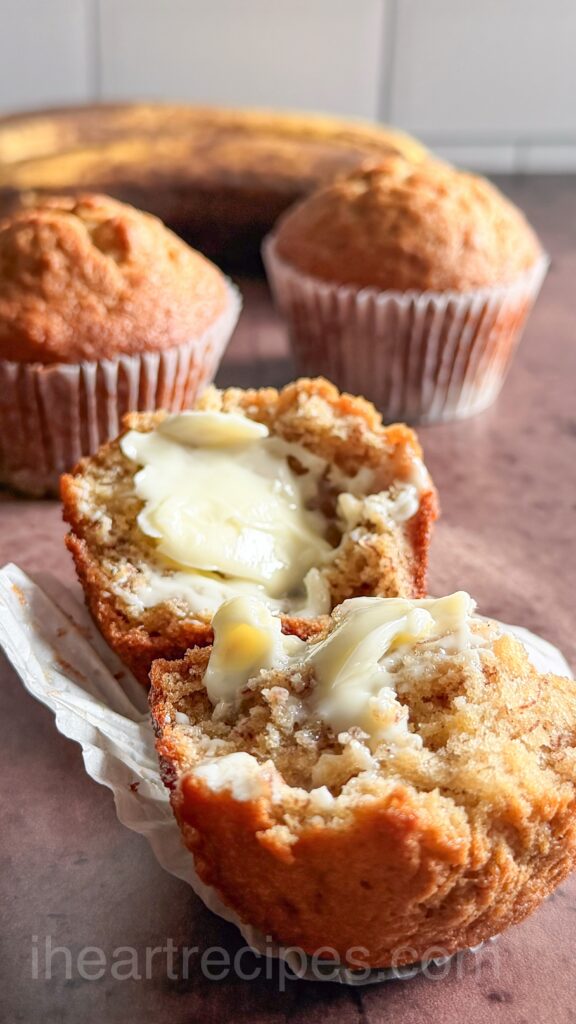 warm muffin sliced in half with soft butter slathered on each slice.