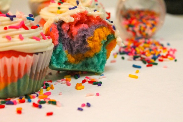 DIY Rainbow Cupcakes sprinkled with colorful candies. 