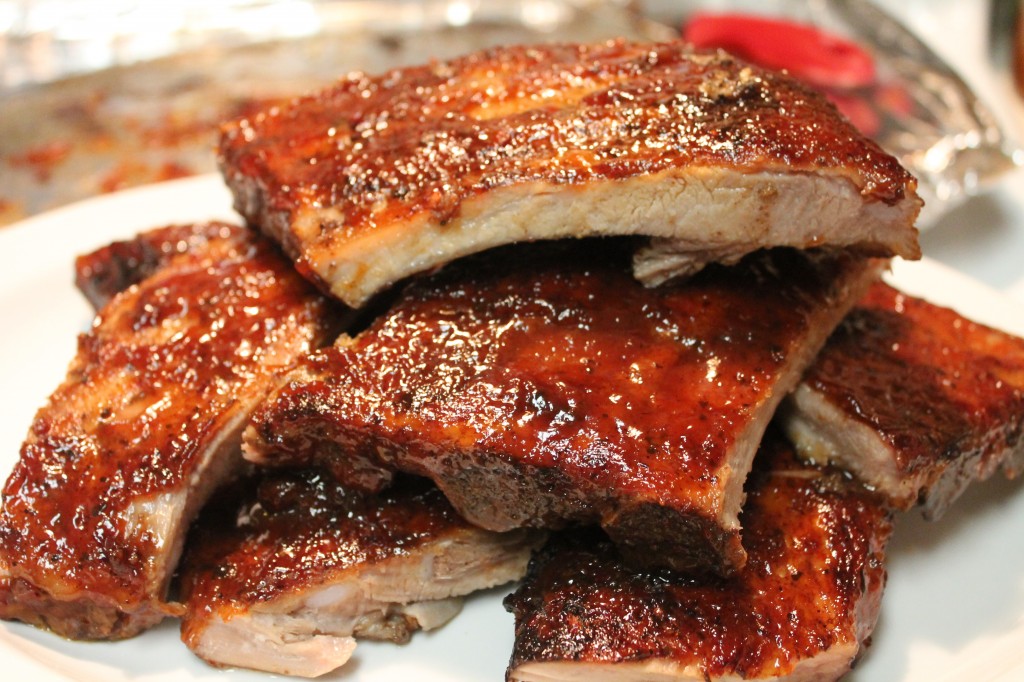 Tender, juicy crockpot barbecue ribs stacked on a white plate. This is a great way to enjoy ribs without the necessity of a grill.