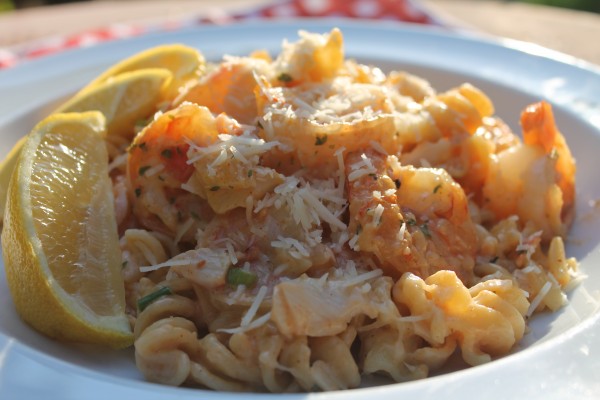 Creamy Seafood Louie Pasta topped with freshly grated cheese and lemon wedges. The perfect meal for your next date night!