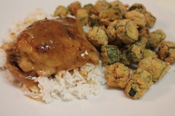 Baked chicken and gravy served over white rice with a side of breaded fried okra—a deliciously Southern dinner!