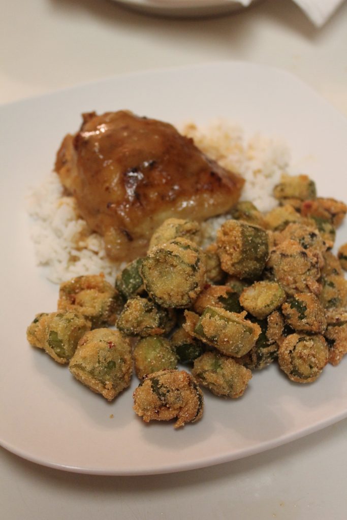 Southern fried okra served with a smothered pork chop over a bed of white rice. Fried okra is a great side to serve with savory soul food.