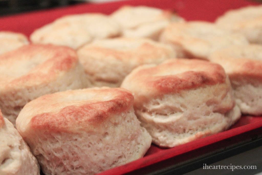 Rows of golden, fluffy buttermilk biscuits on a red platter.