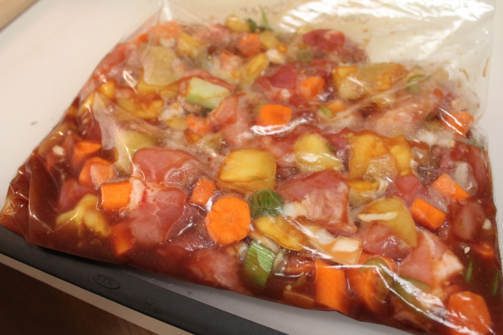 A storage bag filled with sweet and sour pork ready for the freezer.