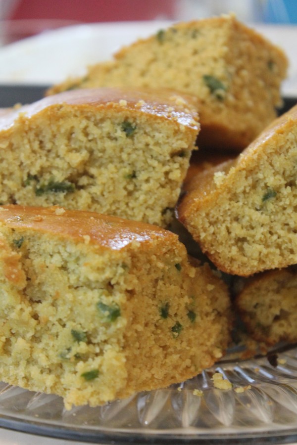 A plate full of honey jalapeno cornbread slices—a sweet and spicy homemade cornbread topped with honey butter and diced jalapenos in each bite.