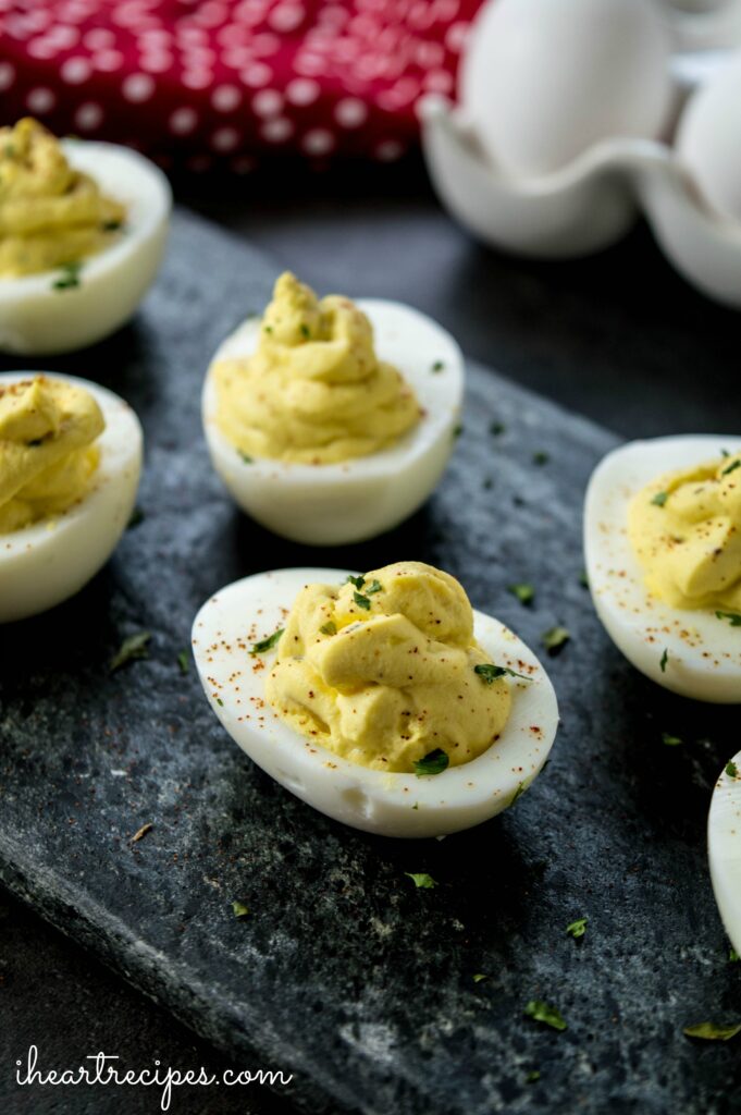 Six Southern Deviled Eggs served on a black marble serving platter. 
