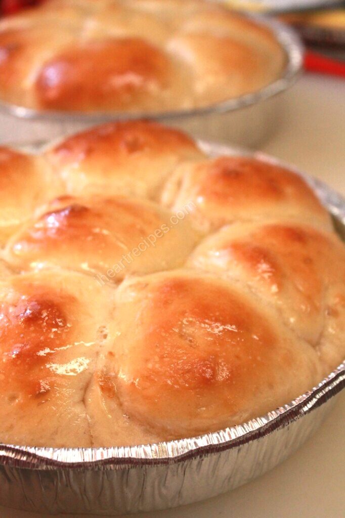 Buttery, golden brown, homemade dinner rolls in a silver tin pan. 