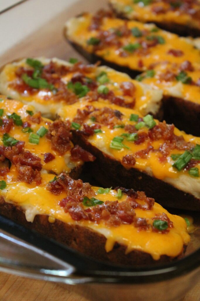 Rows of crispy twice baked potatoes topped with bacon, melted cheese and green onions. 