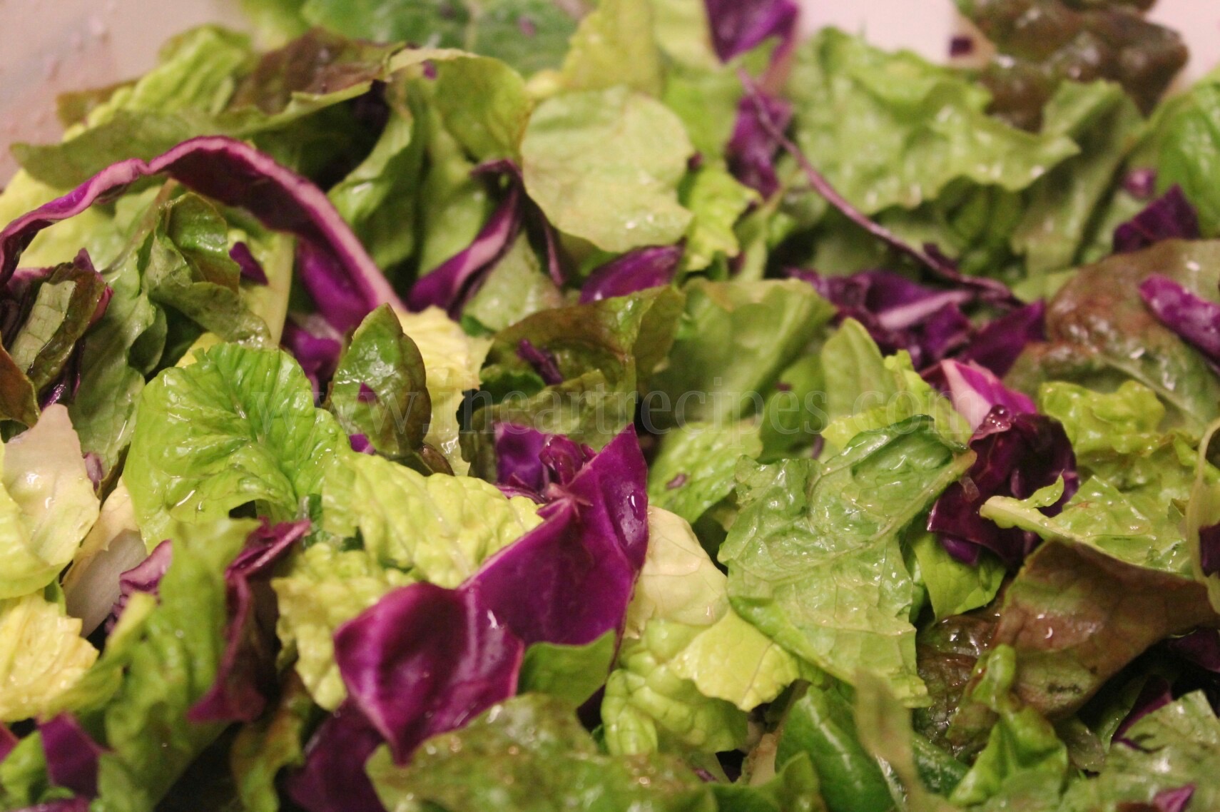 Washed, shredded red cabbage and torn green lettuce tossed together. 