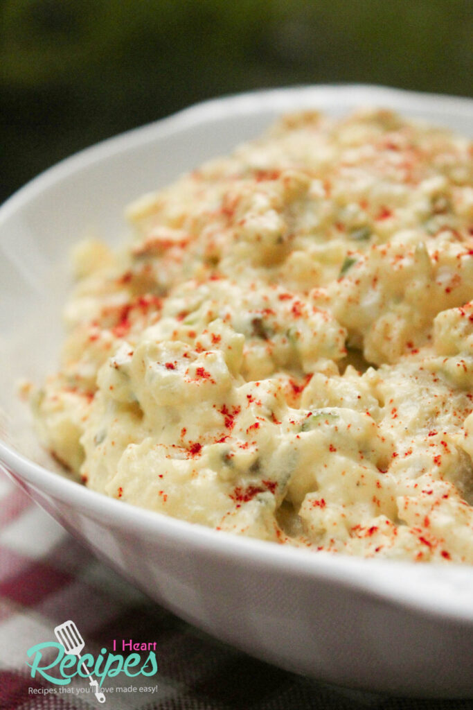 Southern potato salad made with Hellmann's mayonnaise fills a white serving dish. 