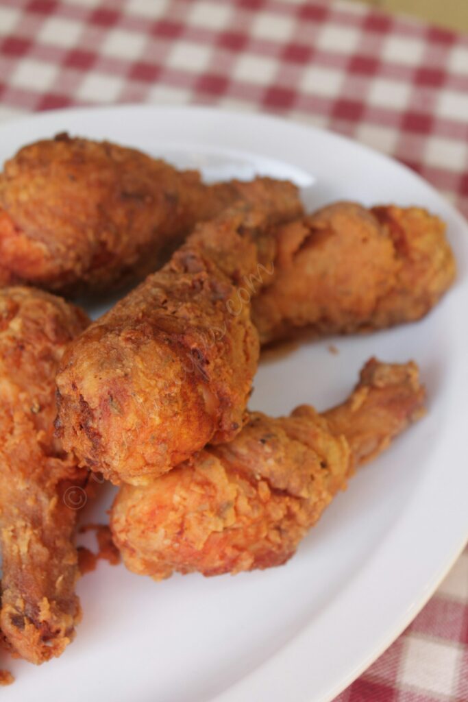 Golden Coconut Curry Fried Chicken layered on a white serving platter. 
