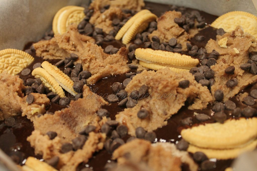 Oreo Chocolate Chip Brownies swimming in golden Oreos, chunks of cookie dough and creamy chocolate chips. This panful of goodness is ready for the oven!