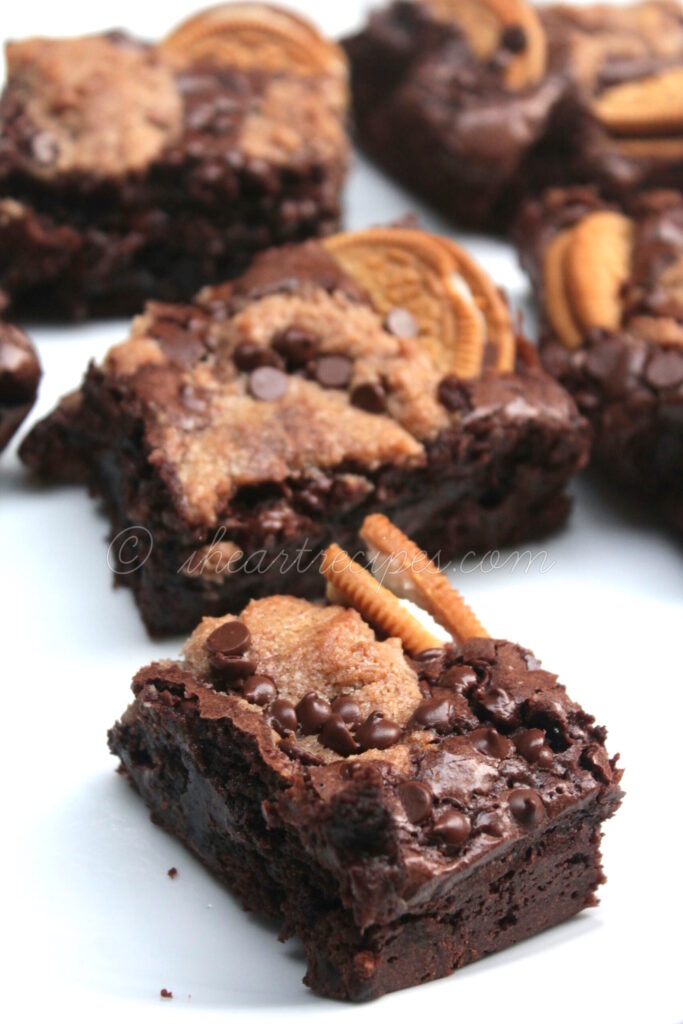 Squares of ooey-gooey golden Oreo Chocolate Chip Brownies arranged on a white platter. What a sweet treat!