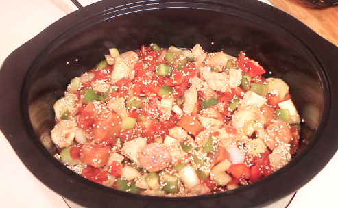 Chopped meat, veggies and quinoa along with seasonings in a large black Crock-Pot.