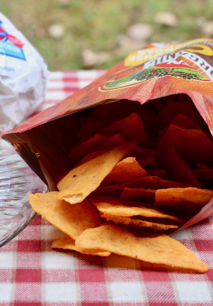 Crunchy seasoned chips on a picnic blanket. A variety of chips are a must-have for any party!