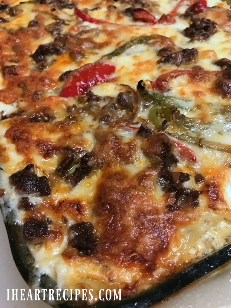 A glass baking dish filled to the brim with cheesy Philly Cheesesteak Lasagna!