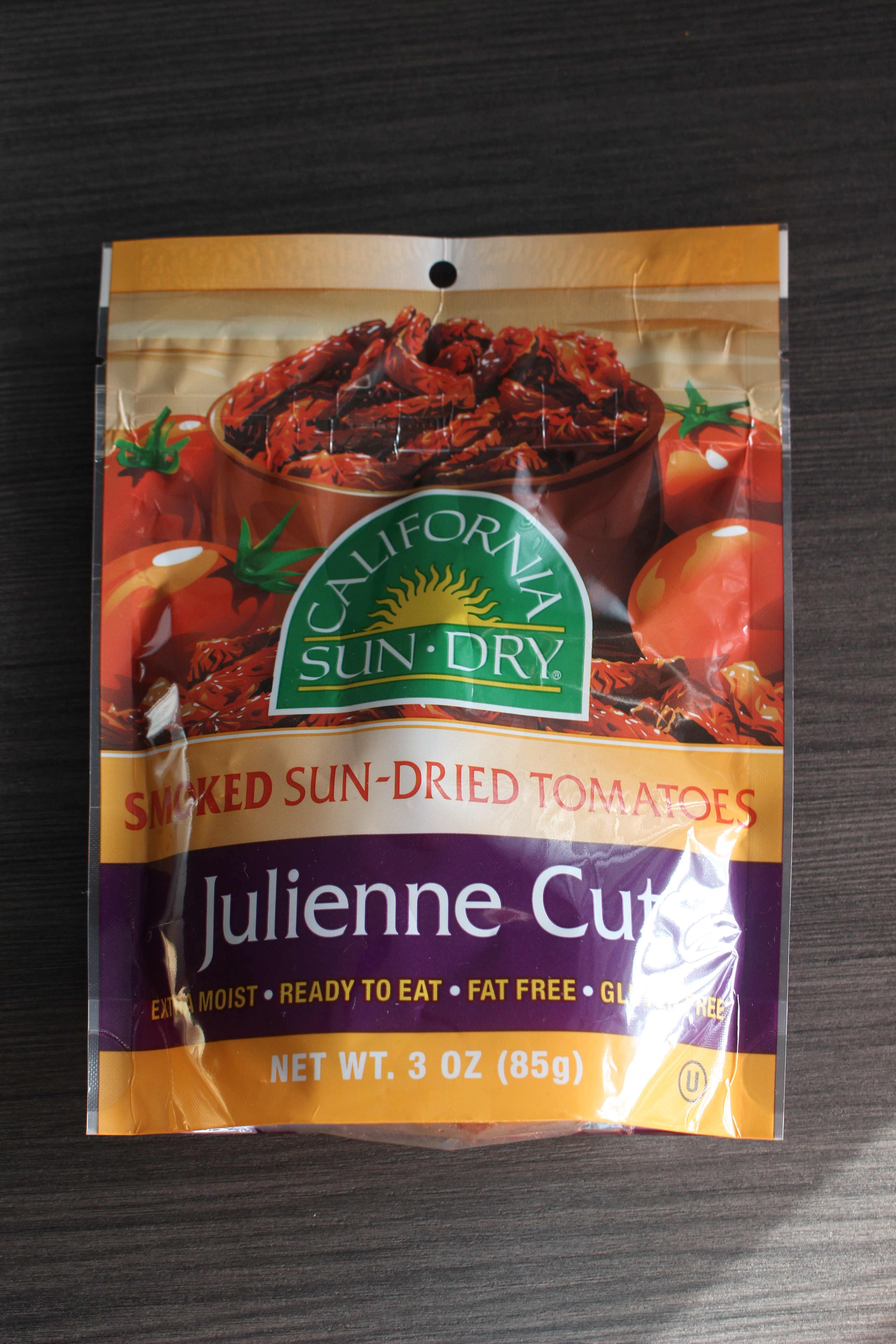 Prepackaged julienne cut sun-dried tomatoes on a wooden table. This brand and type is perfect for this spaghetti pasta salad recipe.