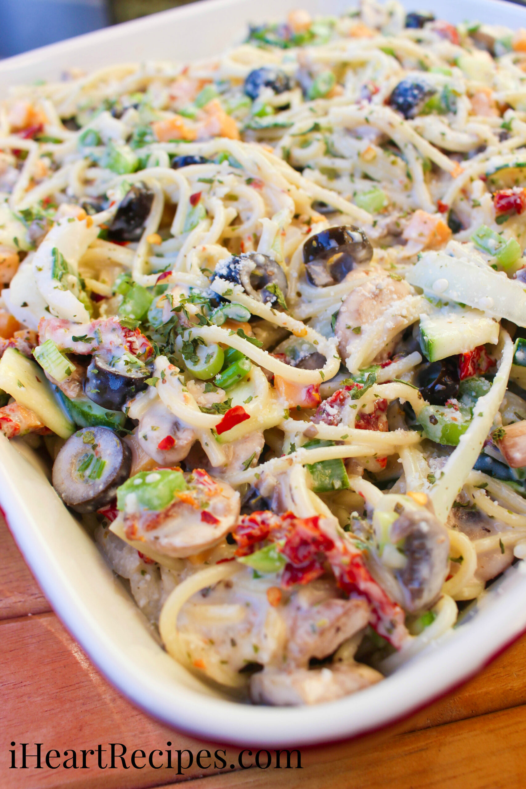 Tender spaghetti, fresh veggies and a creamy sauce piled high in a red serving dish. This spaghetti pasta salad is delicious and simple!