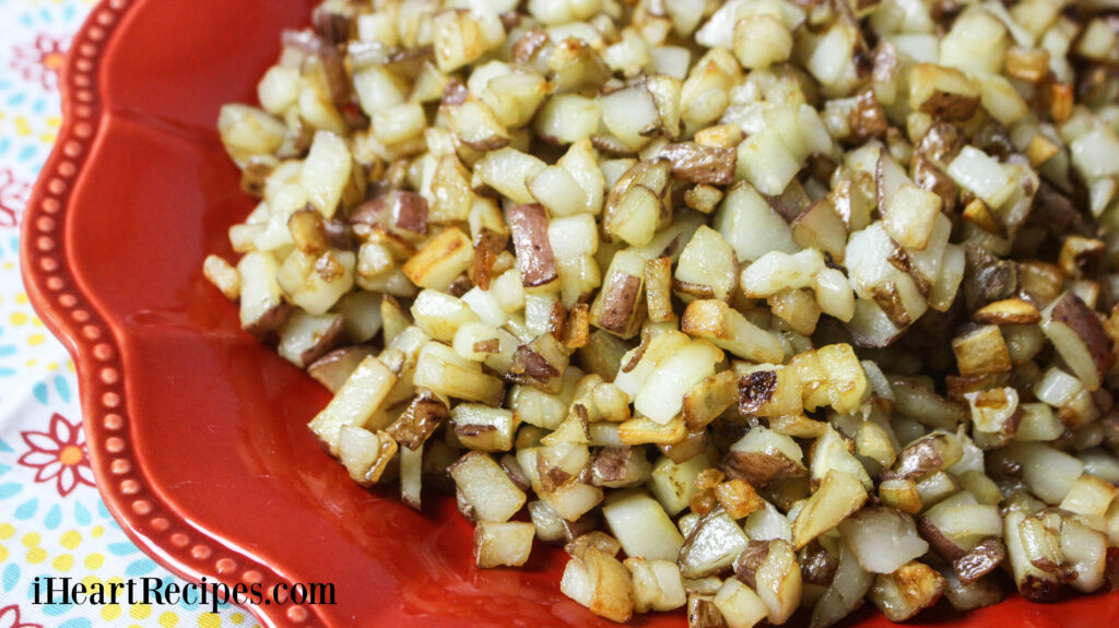 Buttery and tender Southern Hash Browns served on a red scalloped plate. 