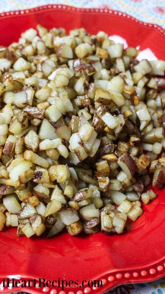 Perfectly seasoned Southern Hash Browns piled high on a red scalloped serving dish. 