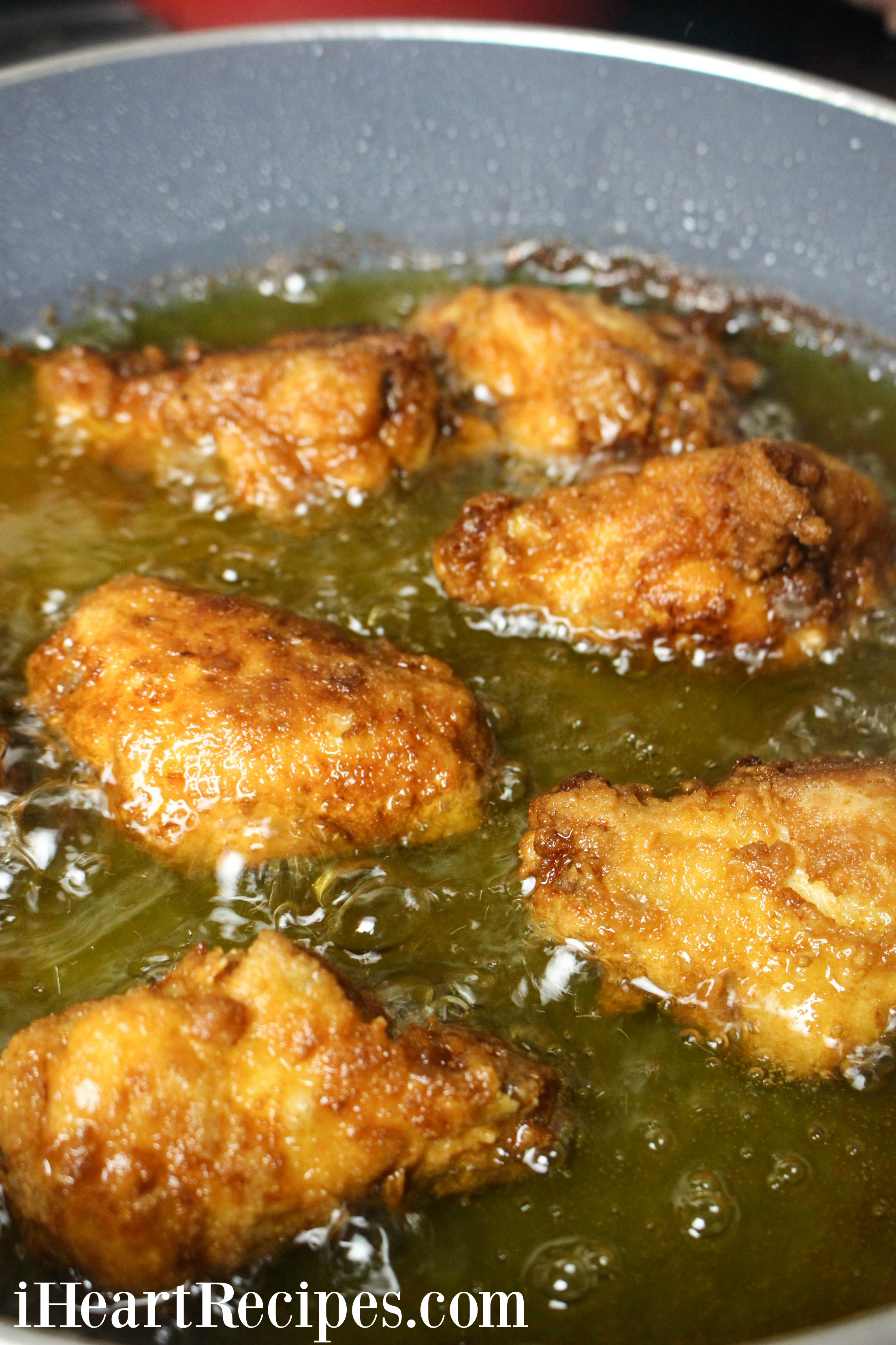 Tender waffle batter chicken wings frying in golden oil.  