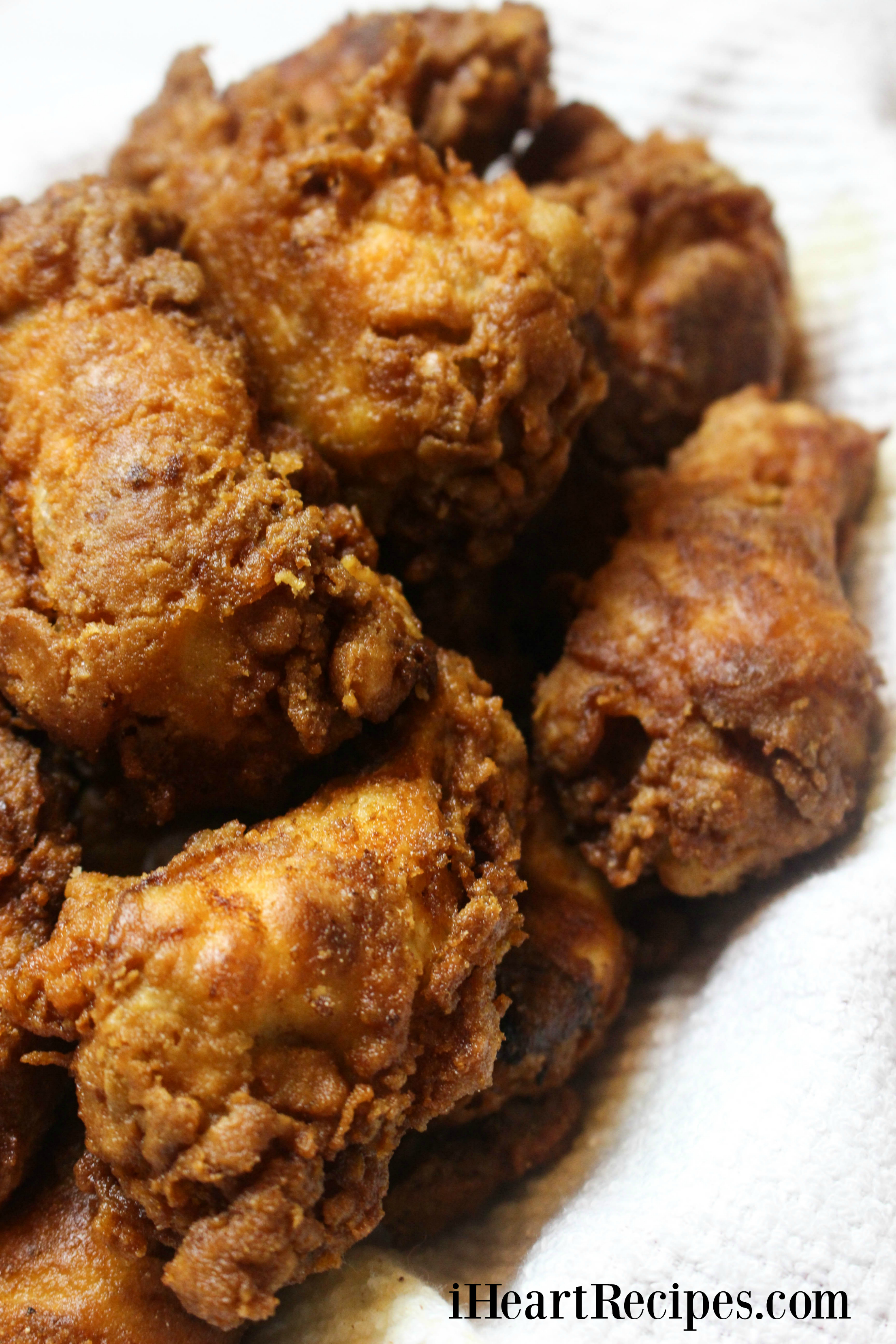 Golden, crunchy, and perfectly-fried chicken wings served on a towel-lined platter. 