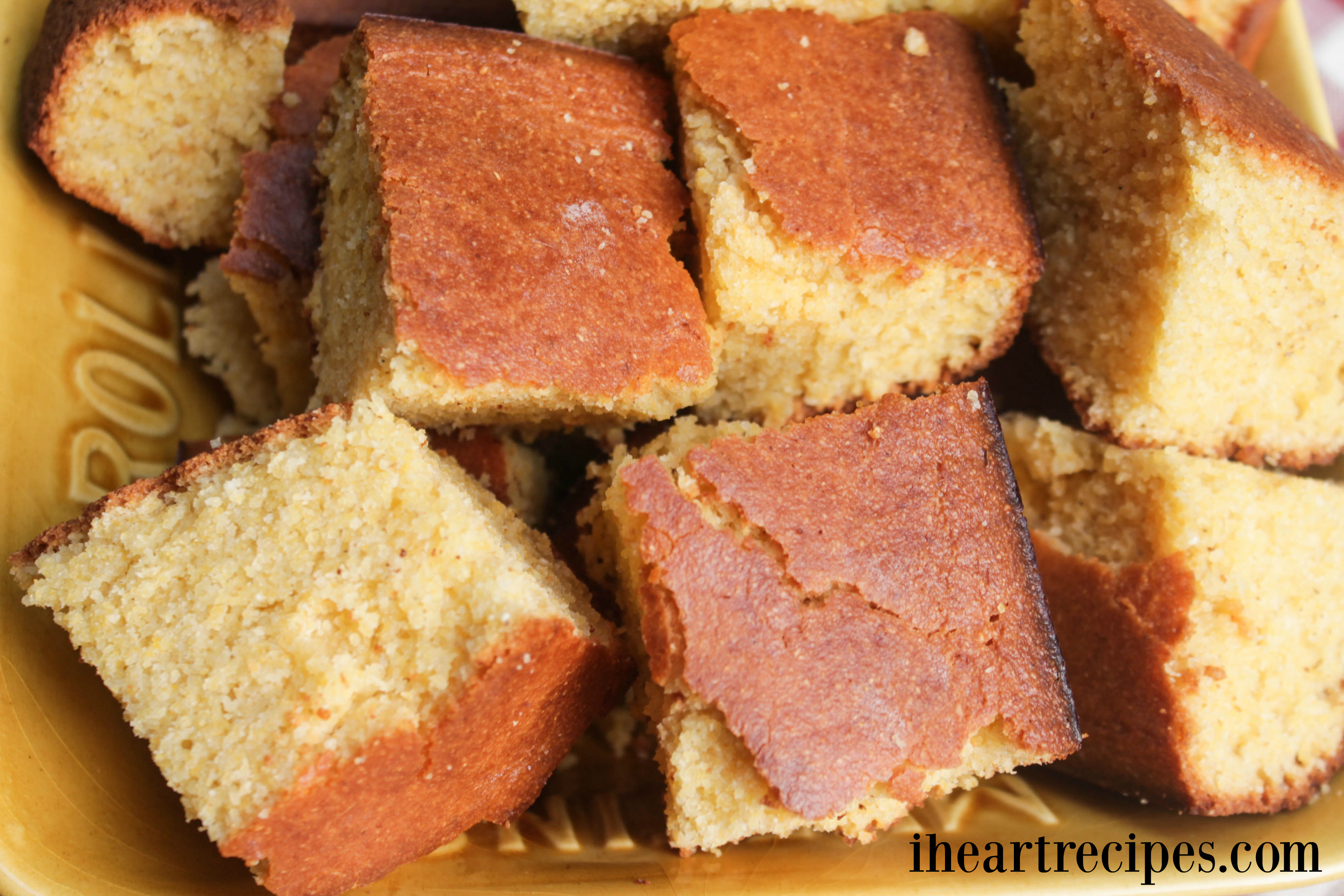 Moist and delicious squares of southern style cornbread served in a yellow dish. 