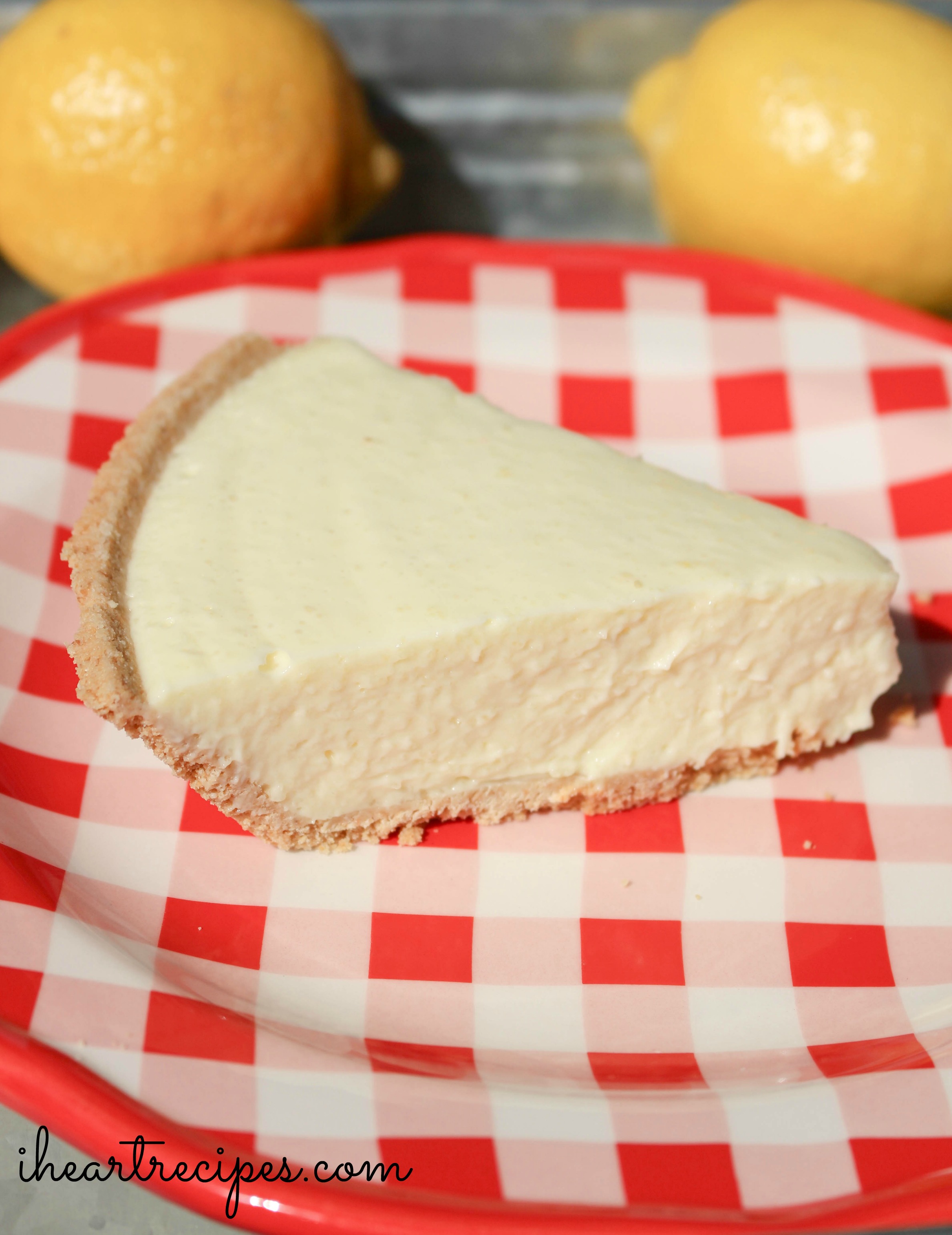 A creamy no-bake lemon cheesecake slice served on a red and white checkered plate just waiting to be enjoyed!