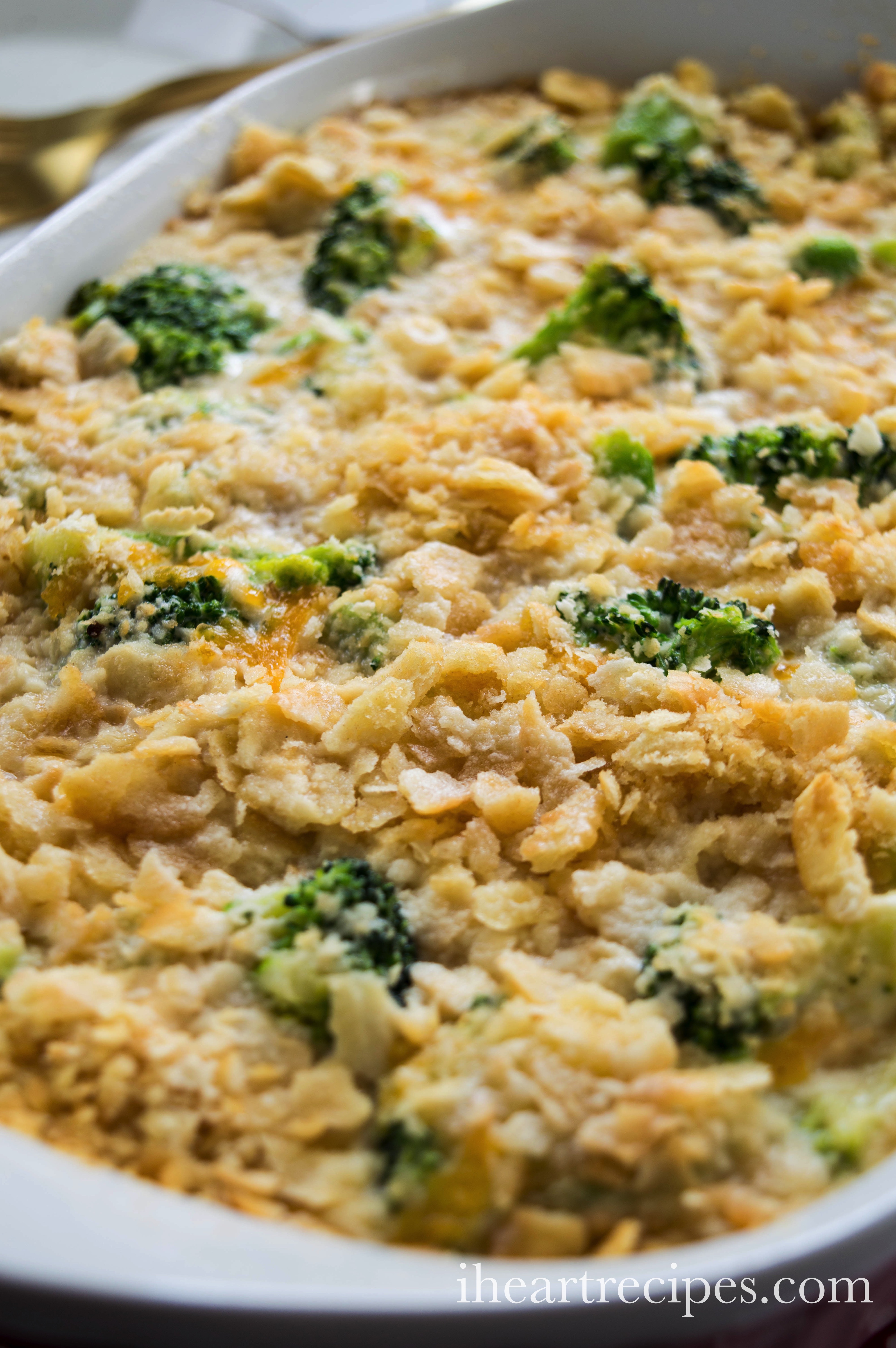 A close-up image of a dish full of cheesy broccoli casserole that’s topped with crumbled crackers and filled with tender broccoli and cheddar cheese cooked in a creamy sauce.