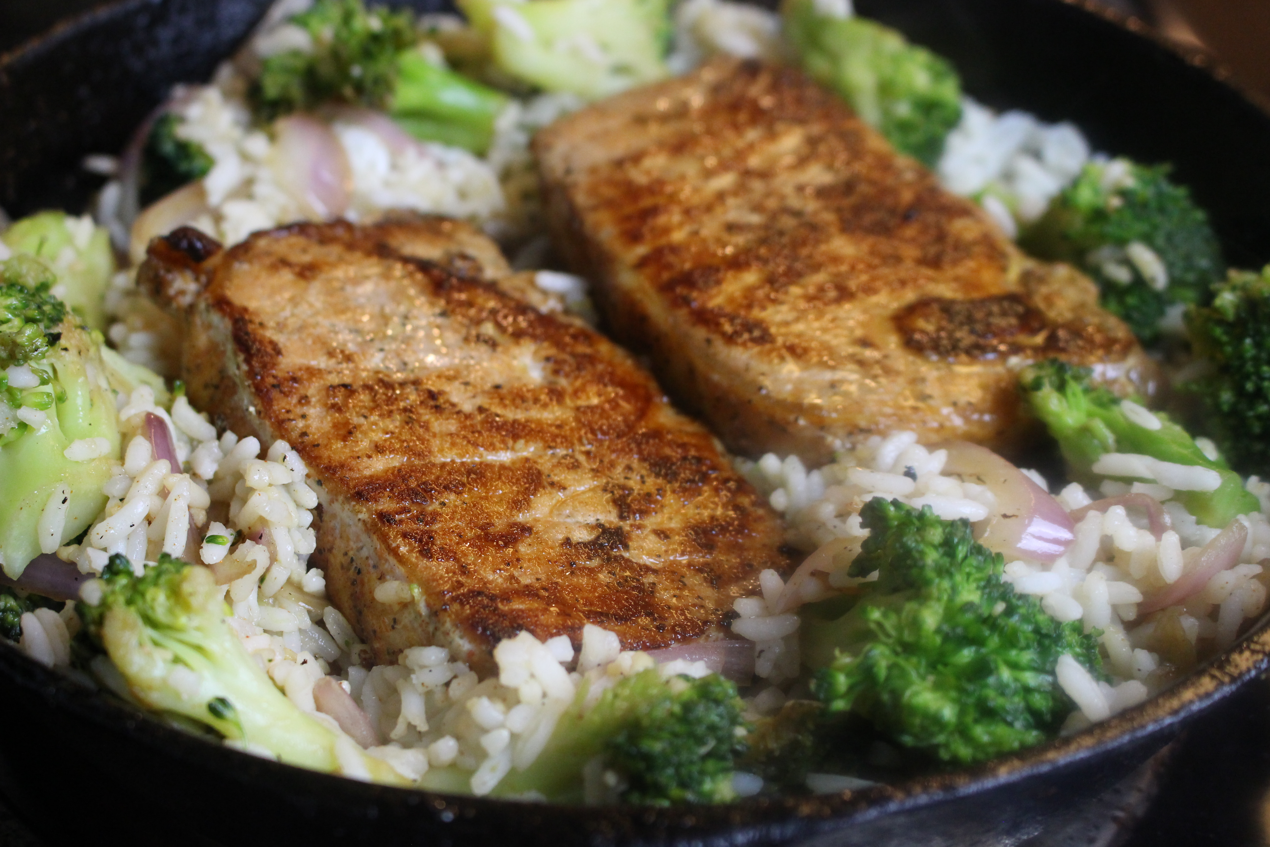 Tender pork chops with a lightly seasoned crust served on a bed of rice and broccoli. This one-pot dinner is a simple weeknight meal!