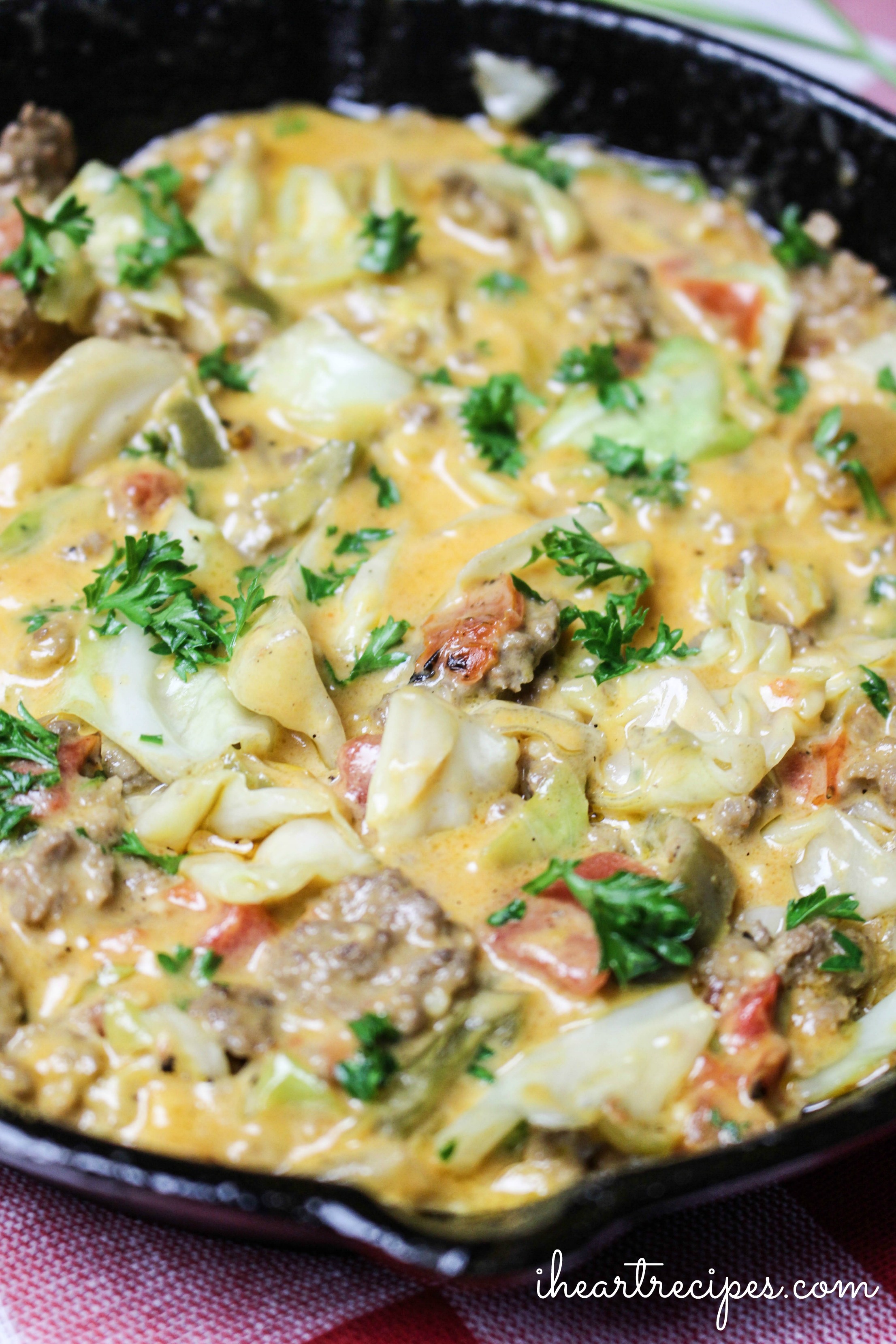 Creamy Cheesy Cabbage Creole topped with bits of bright green parsley served in a cast iron skillet. This is a meal the whole family will love!