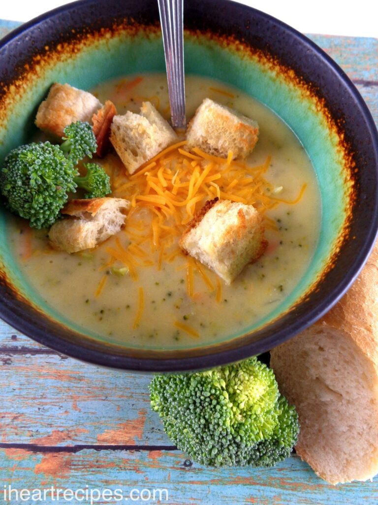 Broccoli Cheddar Soup garnished with fresh broccoli, croutons and shredded cheese. 