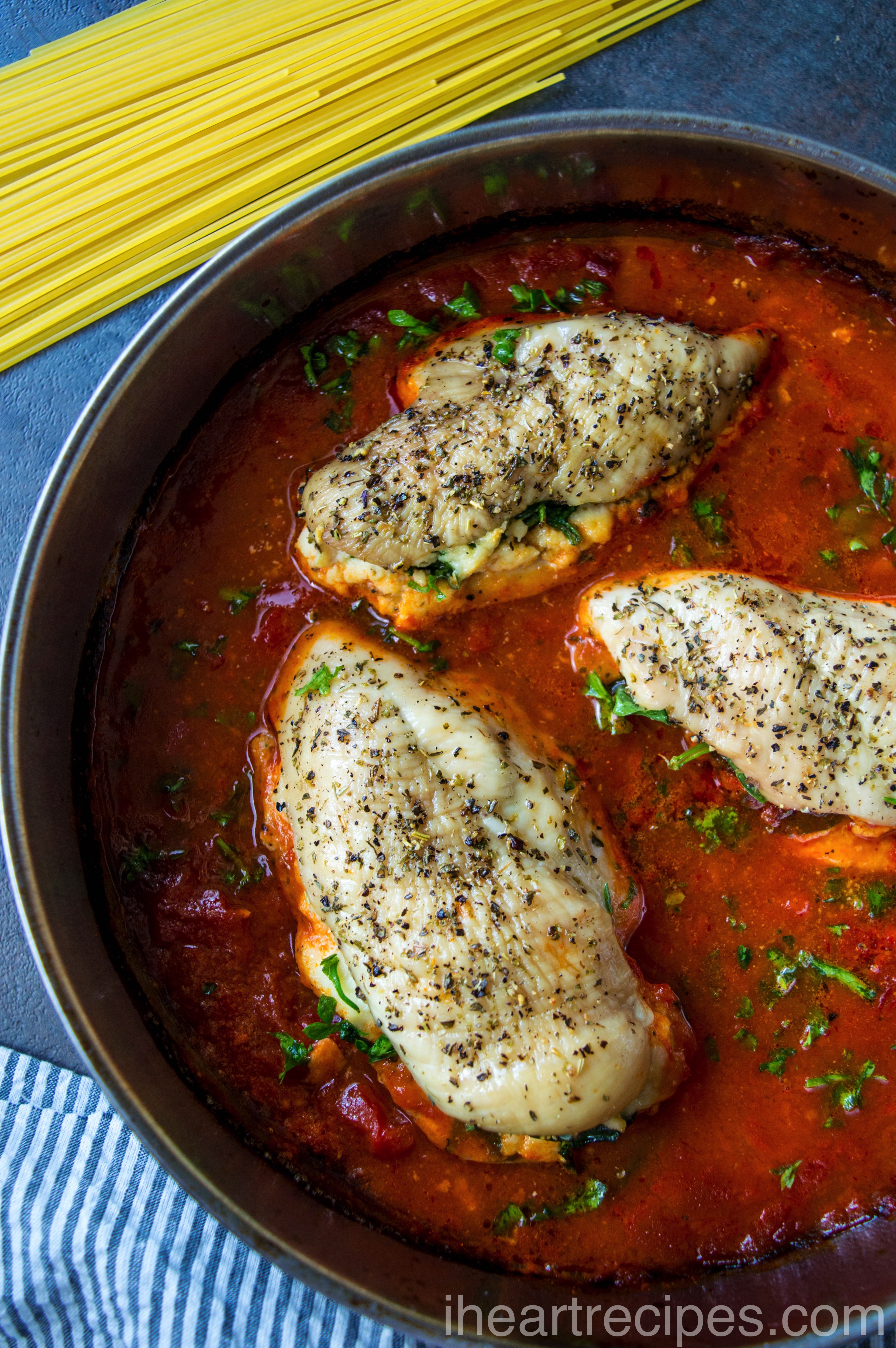 Tender Stuffed Chicken Breasts simmering in a hearty marinara sauce inside a gleaming metal pot. This dish is bursting with flavor!