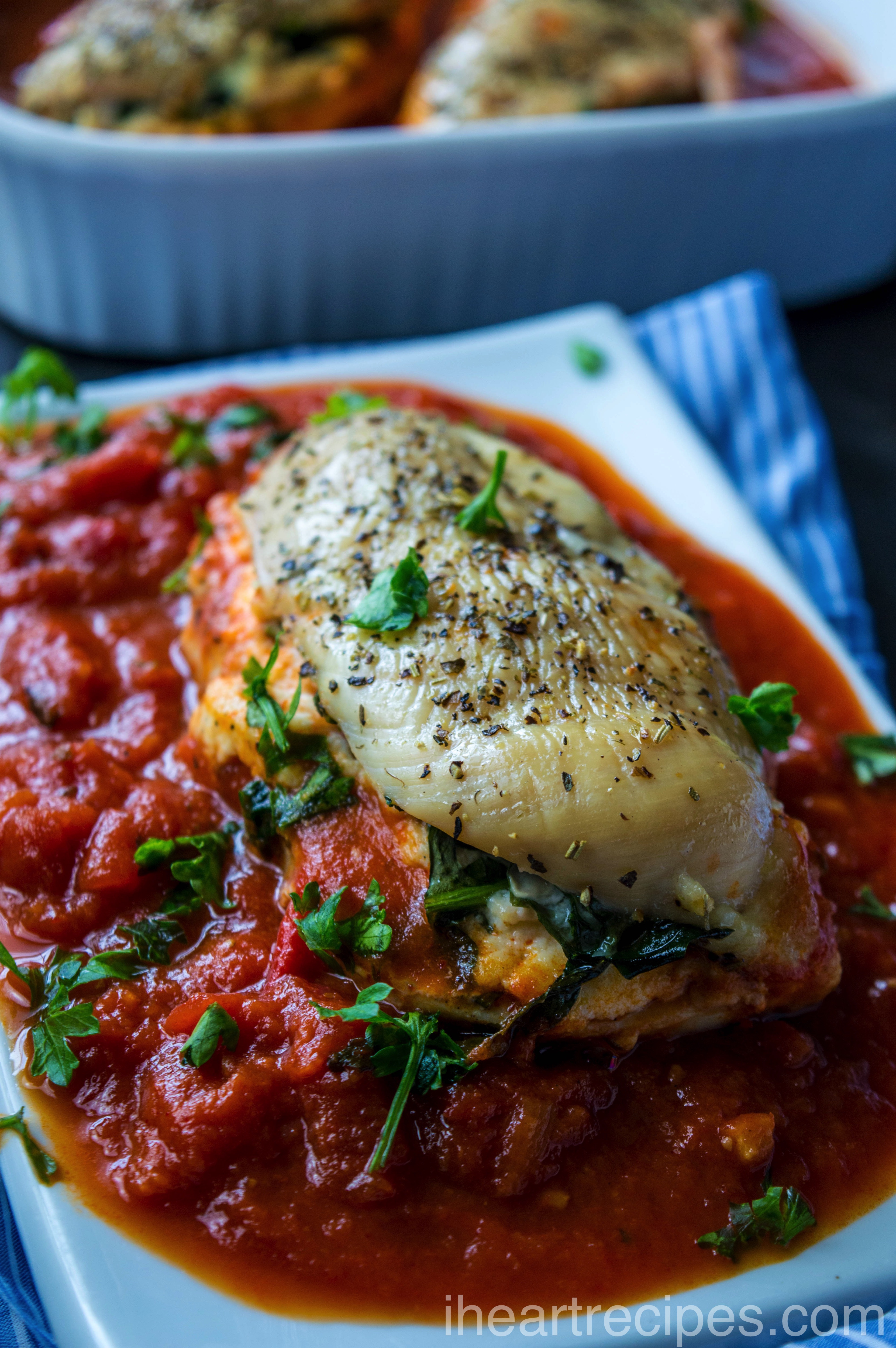 Tender and juicy chicken stuffed with a creamy ricotta cheese and spinach mixture served on a simple white plate. 