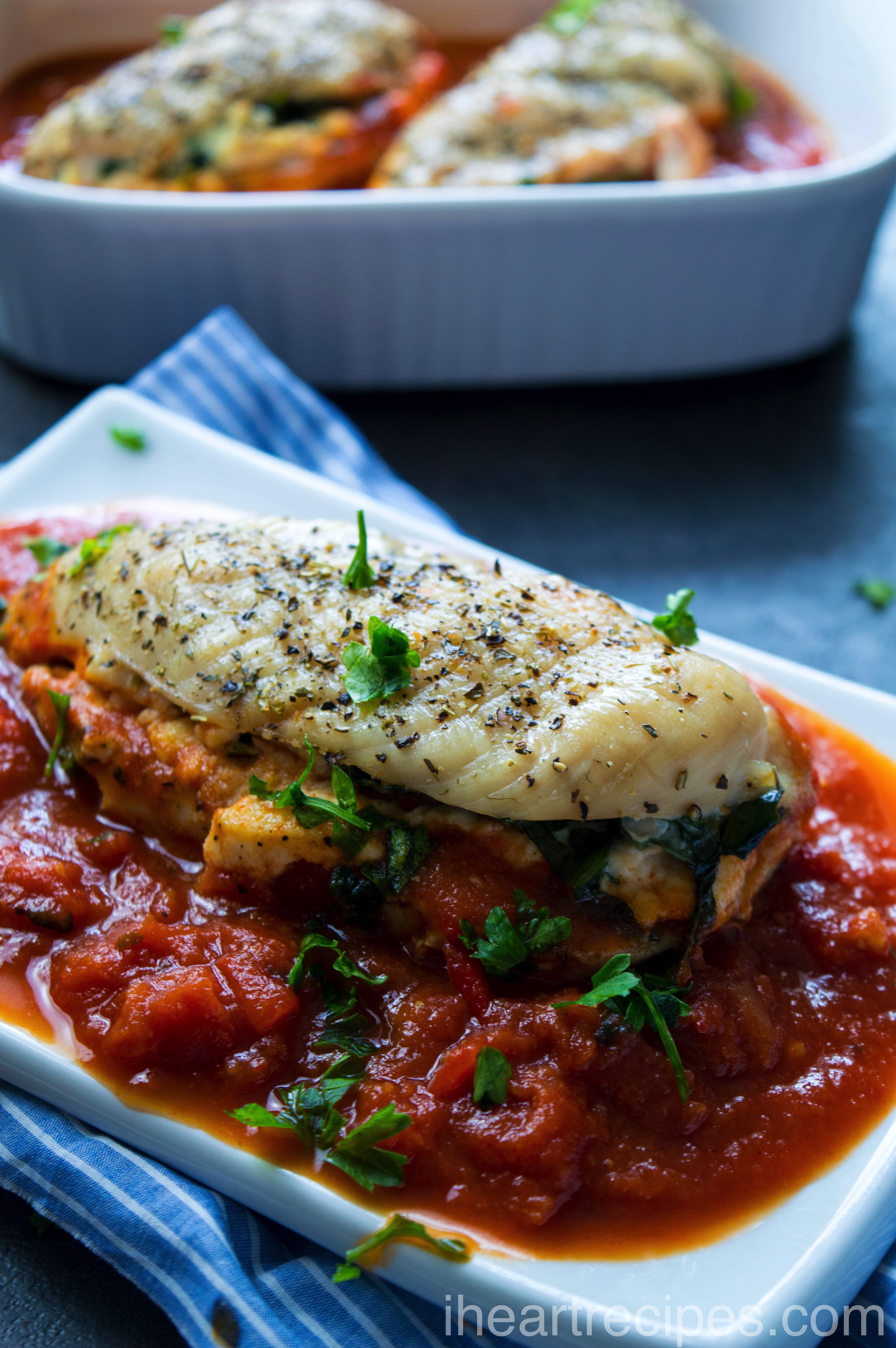 Creamy ricotta cheese and tender spinach stuffed into juicy chicken breasts served on a bed of savory marinara and garnished with bright green parsley. 