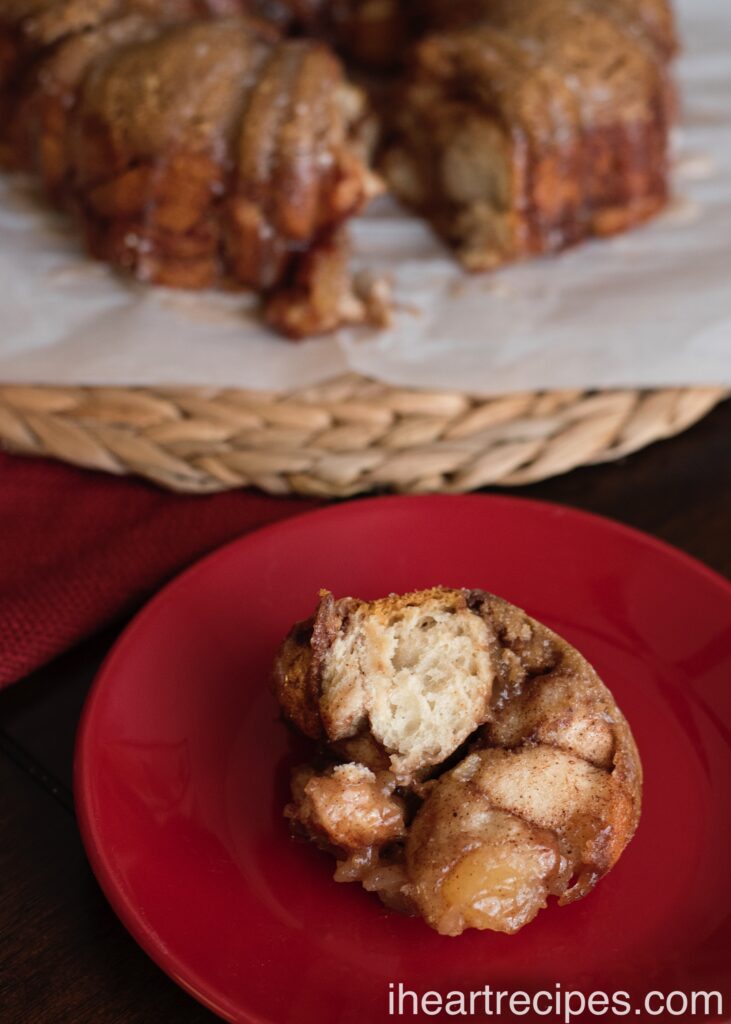 A tender slice of monkey bread full of tart apples and aromatic cinnamon sitting on a round red plate.