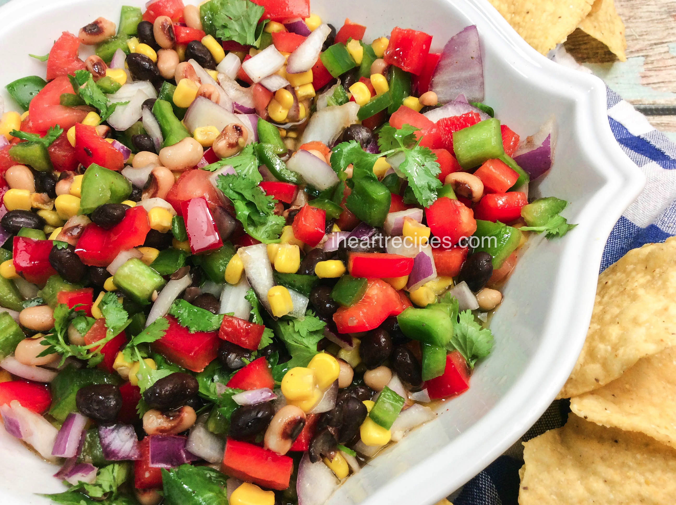 Easy Texas Caviar bursting with color and flavor served in a white serving dish and garnished with tortilla chips for the perfect party snack!