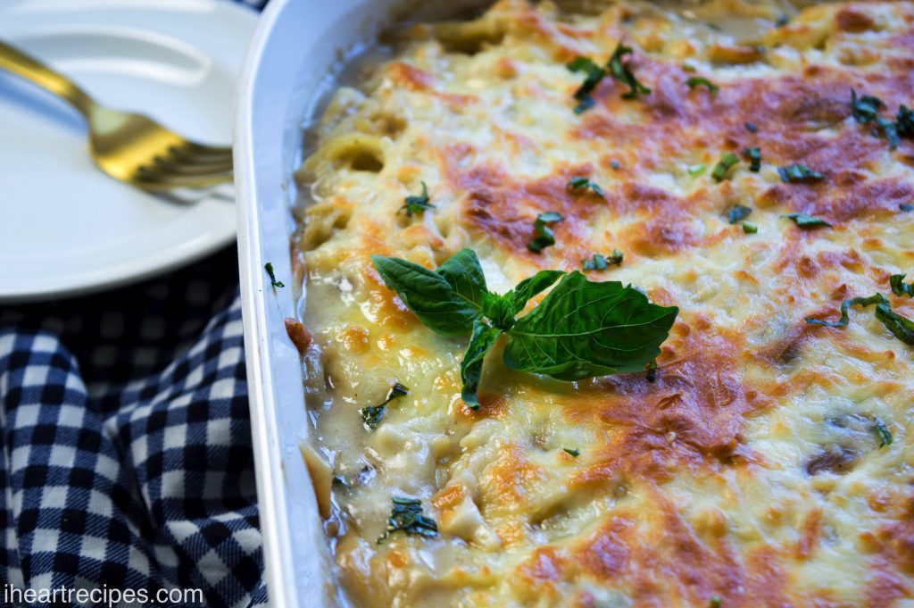 A casserole dish filled with creamy chicken Tetrazzini and garnished with fragrant basil. 