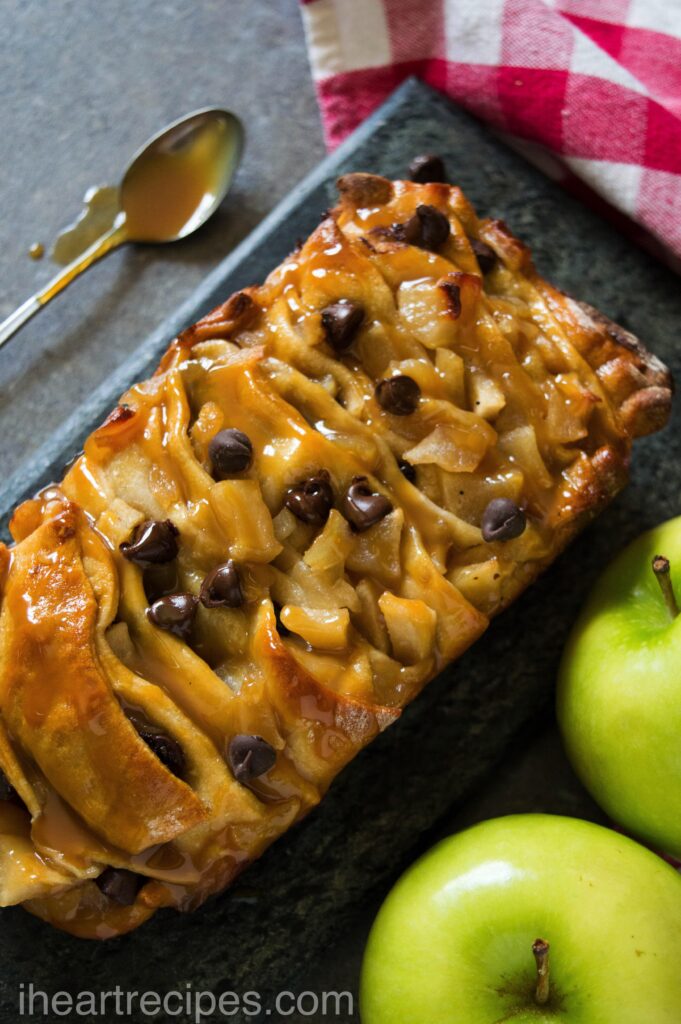 An overhead shot of golden Caramel Apple Pull Apart Bread sprinkled with chocolate chips and drizzled with sweet caramel sauce.