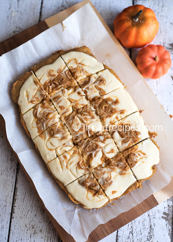 Delicious homemade pumpkin cheesecake bars served on a rustic platter are the perfect fall treat!