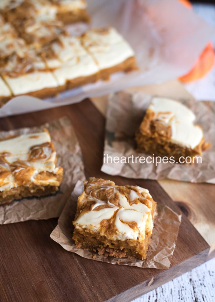 Super creamy cheesecake swirl tops these soft gooey pumpkin bars for the ultimate fall comfort dessert!