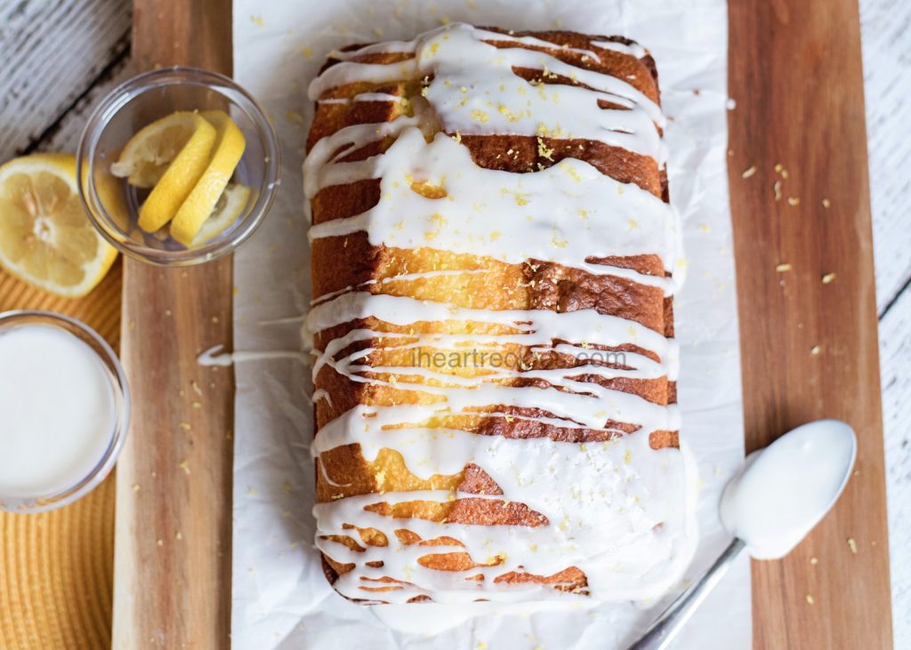 Lemon Loaf Pound Cake drizzled with white glaze and garnished with lemon zest. 