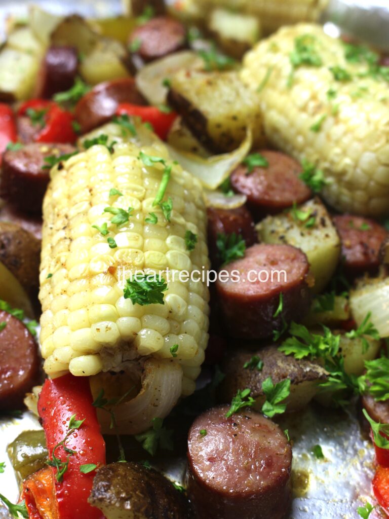 A sheet pan low country broil with sausage, corn on the cob, and peppers.
