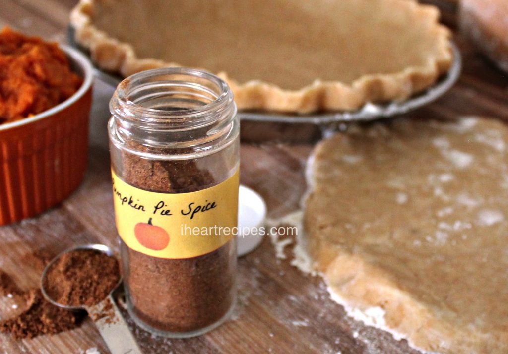 A jar of Pumpkin Pie Spice on a wood counter.