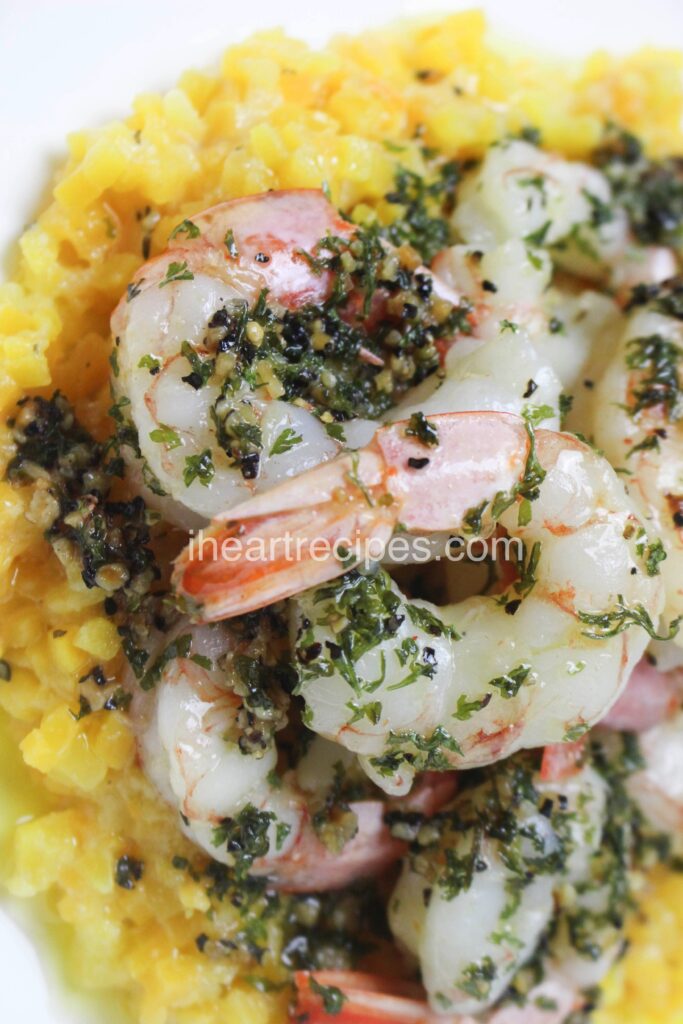 A close-up of tender sautéed garlic butter shrimp served over golden  butternut squash risotto.